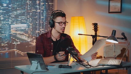 Wall Mural - Home recording studio: the speaker in headphone reads the story into the microphone. There is a computer and other recording equipment on the table.