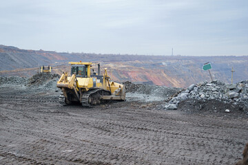 Wall Mural - Bulldozer work in the iron ore quarry. Laying and cleaning roads with a crawler bulldozer in open-pit mining