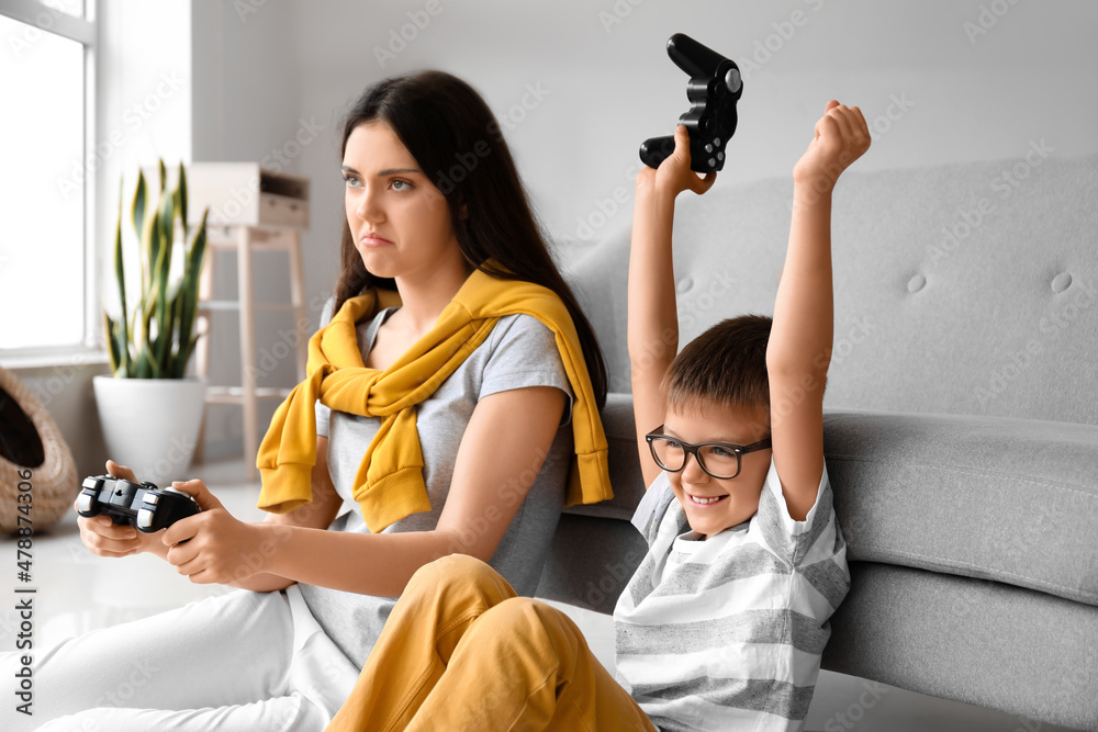 Little boy with his older sister playing video game at home