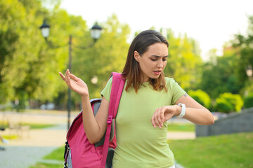 Wall Mural - Young female tourist using smartwatch for navigation in park