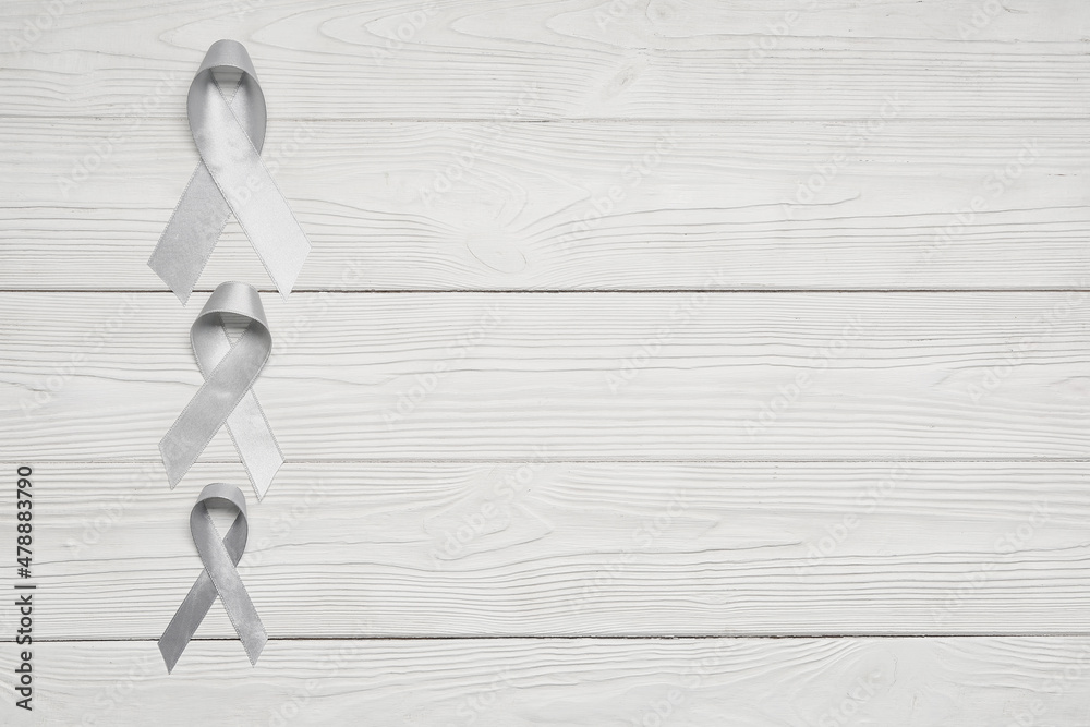 Parkinson's awareness ribbons on white wooden background