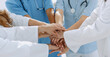 © ASDF - Doctors and nurses stacking hands. concept of mutual aid.
