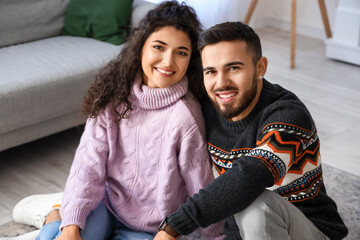 Sticker - Happy young couple wearing warm sweaters at home