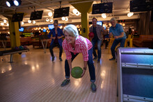 Woman Bowling Between Legs At Bowling Alley