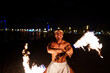 © Igor Kardasov/Stocksy - fire show performer twists a fire rod