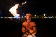 © Igor Kardasov/Stocksy - tribal man doing a fire show on the beach