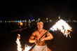 © Igor Kardasov/Stocksy - fire show performer twists a fire rod