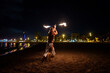 © Igor Kardasov/Stocksy - man holds burning fire batons in his hands