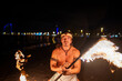 © Igor Kardasov/Stocksy - fire show performer twists a fire rod
