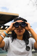 © Kike Arnaiz/Stocksy - Woman looking through binoculars in safari
