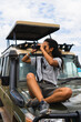 © Kike Arnaiz/Stocksy - Woman looking through binoculars in safari