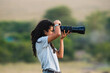 © Kike Arnaiz/Stocksy - Arab woman taking photo in savanna