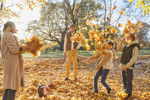 Family Playing With Autumn Leaves