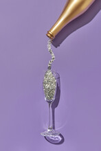 Silver Glitter Pouring Into Glass From Bottle