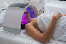 Woman Under A LED Light Facial Therapy Lamp