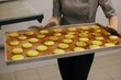 © Liliya Rodnikova/Stocksy - Anonymous baker hold tray with cookies