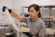 © Liliya Rodnikova/Stocksy - Сonfectioner peeling wrap from fresh made cake