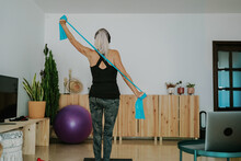 Woman Doing Fitness With Elastic Band At Home
