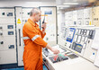 © Igor Kardasov/Stocksy - engineer holding telegraph in engine room