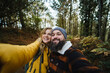 © Daniel Gonzalez/Stocksy - Traveling couple taking selfie in forest