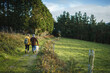 © Daniel Gonzalez/Stocksy - Couple walking in park with dog