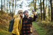 © Daniel Gonzalez/Stocksy - Content couple taking selfie in woods