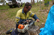 © Rowena Naylor/Stocksy - Man sharpening chainsaw