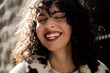 © Olga Kozicka/Stocksy - Woman With Curly Hair Laughing
