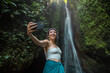 © Jovo Jovanovic/Stocksy - Female tourist taking selfie in jungle