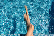 beautiful slender female legs in the hotel's swimming pool. Summer vacation concept in the water.