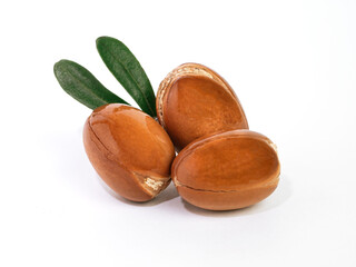 Wall Mural - Moroccan Argan nuts with green leaves on white isolated background. Argan seeds, for the production of oil
