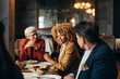 © Studio Firma/Stocksy - Business People Having Lunch in Restaurant