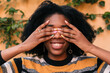 © Lucas Ottone/Stocksy - Smiling woman covering her face