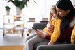 © Studio Marmellata/Stocksy - Diverse nanny and girl using tablet