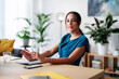 © Studio Marmellata/Stocksy - Smiling woman working in modern office