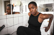 © Ivan Ozerov/Stocksy - African American woman leaning on sink