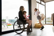 © Santi Nuñez/Stocksy - Mother in wheelchair playing with her daughters