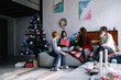 © Oleksii Syrotkin/Stocksy - Happy female teen unwrapping Christmas presents at home