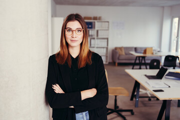 Confident young businesswoman wearing glasses in an office