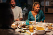 © BONNINSTUDIO/Stocksy - Diverse friends sitting at dinner table