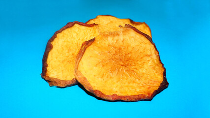 Wall Mural - dried peach chips lie on a blue background. side view. healthy homemade food. dried fruits