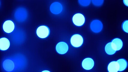 Wall Mural - christmas, holidays and illumination concept - close up of blurred electric garland blue lights in dark room