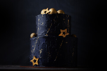 Canvas Print - Black bunk cake on the dark black background with golden stars and spheres decoration on top. luxurious birthday cake