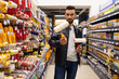 © Ivan Traimak - a buyer in a construction hypermarket is determined with brushes and rollers for painting, the concept of repair and construction of a house