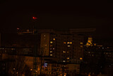 Fototapeta Miasto - Dźwig wieżowy ( żuraw ) nocą , na tle świateł miasta . Budowa , miasto ,noc . 