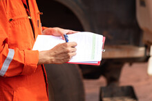 Safety Officer Or Supervisor Is Writing Note On The Checklist Paper During Perform Audit And Inspection In Oil Field Operation. Close-up Action And Selective Focus Photo.