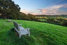 Wooden Bench Looking Over Green Field Countryside Of High Weald On Summer Evening, Burwash, East Sussex