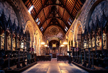 Gothic Style Church Interior With Warm Internal Lighting And Wooden Roof - Stunning Brickwork And Full Wooden Furniture And Pew Seating. 