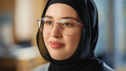Aufkleber - Beautiful Close Up Portrait of a Multiethnic Muslim Female Wearing Hijab and Glasses, Charmingly Smiling and Posing on Camera. Happy Diverse Young Woman in Casual Clothes Indoors.
