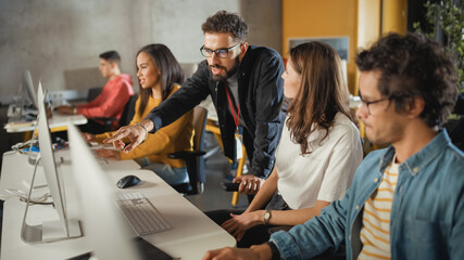 Wall Mural - Lecturer Helps Scholar with Project, Advising on Their Work. Teacher Giving Lesson to Diverse Multiethnic Group of Female and Male Students in College Room, Teaching New Academic Skills on a Computer.